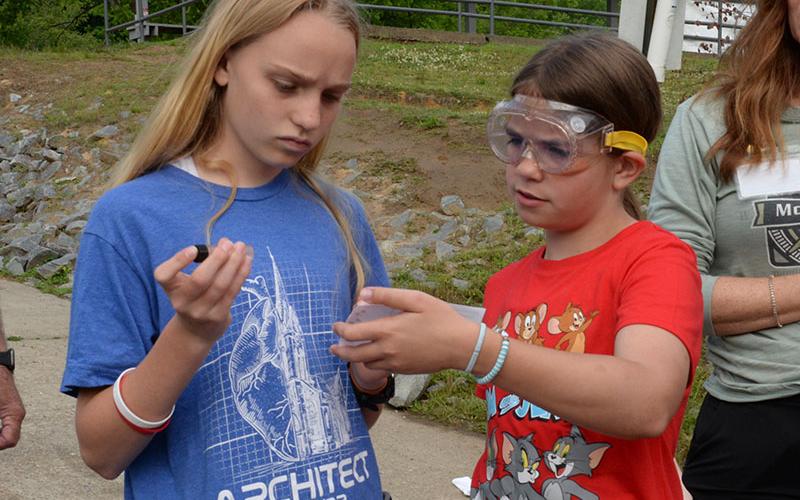 Jacquelyn Cline, left, and Jayden Collins tested the Toccoa River waters to make sure the water holding their rainbow trout was compatible for the tiny fish to be relocated. Both the temperature and PH levels of the two sites had to be compatible to safely move the fish.