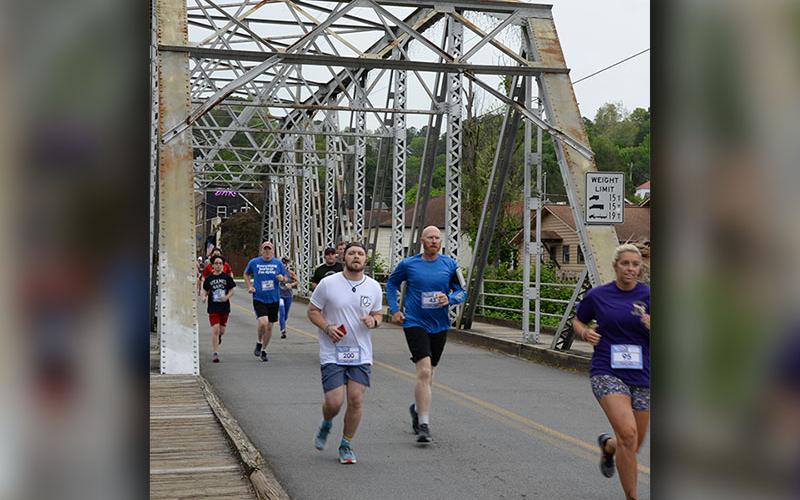 Runners cross the historic steel bridge in McCaysville that crosses the Toccoa River. The bridge is one of the scenic draws the race boasts.