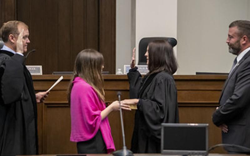 Amanda Mercier takes her oath as the Chief Judge of the Georgia Court of Appeals from Judge Brian M. Rickman  who she is succeeding. Holding the Bible is daughter, Alexandria, as husband, Joe Foster, watches the event.