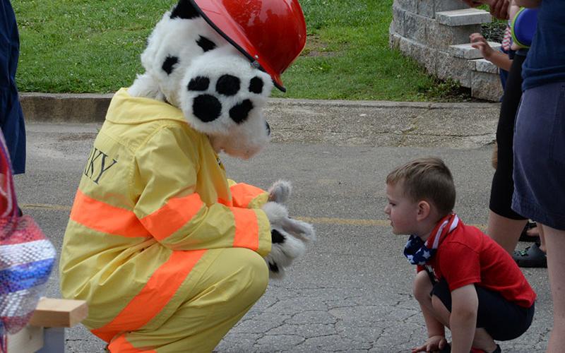 Smoky, the Fannin County Fire Department’s mascot, visited with this youngster before the start of the Old Timer’s Parade.