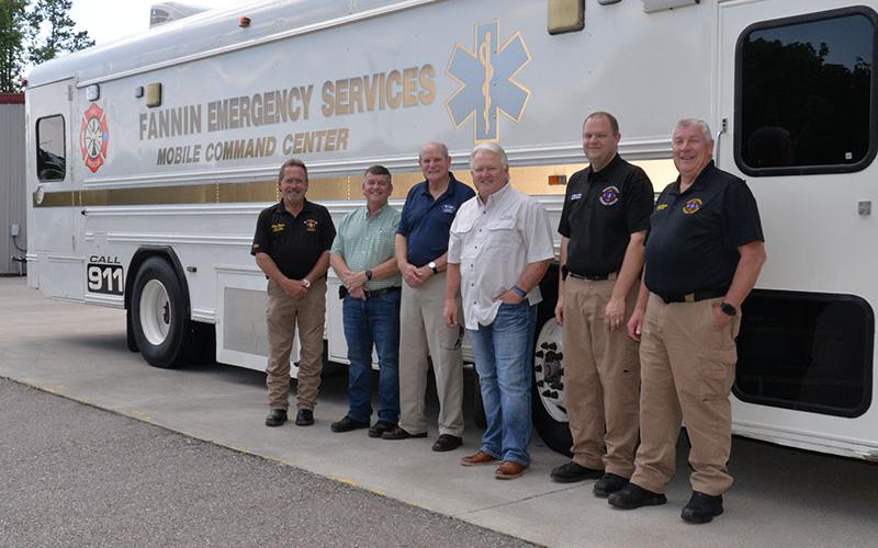Fannin County officials unveiled the Emergency Management Agency’s (EMA) new Mobile Command Center last week. Shown in front of the large bus that is capable of operating the entire 911 communications center are, from left, Fire Chief Larry Thomas, Commission Chairman Jamie Hensley, Post 2 Commissioner Glenn Patterson, Post 1 Commissioner Johnny Scearce, Deputy EMA Director Patrick Cooke and EMA Director Robert Graham.