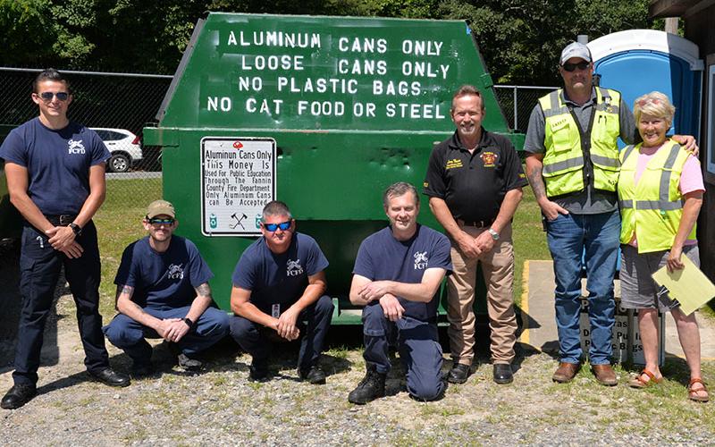 A partnership between the Fannin County Fire Department and WM that sees proceeds go to an education fund is continuing. Shown reminding citizens they can donate aluminum cans at the WM facility in Lakewood are, from left, Channing Johnstone, Michael Cornelius, Brad Beaver, Randy Epperson, Larry Thomas, Nathan Parris, and Charmell Mealer.