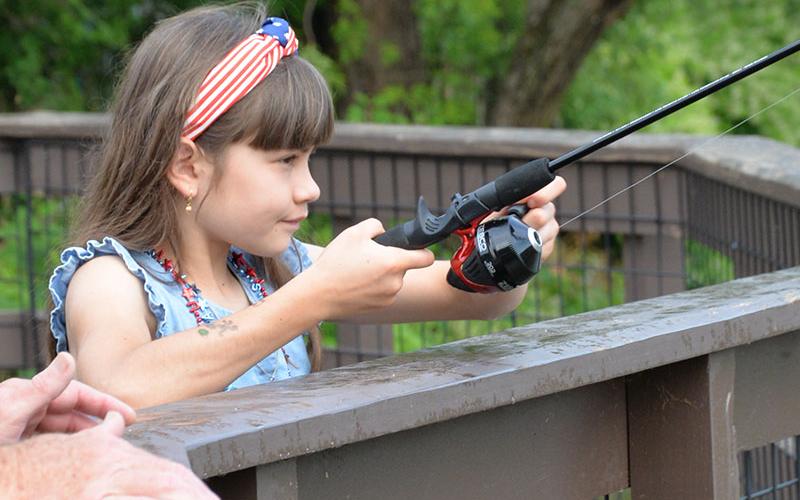 Olivia said she was determined to catch more fish than the boys when she took part in the Fishing Rodeo that kicked off the Independence Day celebration in McCaysville Saturday, July 1. She is shown trying her luck from the deck overlooking the Toccoa River at the Toccoa River Park. The rodeo was followed by free hotdogs, chips and drinks for everyone. A parade and antique car show took place in the afternoon before the annual fireworks display that night.
