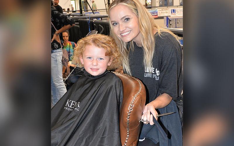 Celeste Lance gets ready to cut Addyson’s hair as part of the Back to School Bash at Fannin County High School Saturday. Sponsors estimated 450 students took advantage of the annual event which featured the free haircuts.