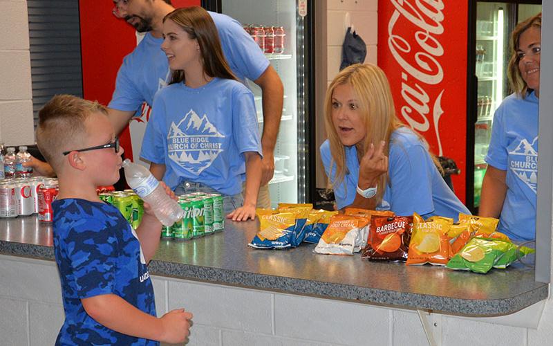 Members of the Blue Ridge Church of Christ stepped up and manned the concession stand at the Back to School Bash. Helping a young man make his choices are, from left, Christian Bauguss, Kathryn Weaver, Tracie Griffith and April McFarland. The volunteers served 400 hotdogs Saturday.