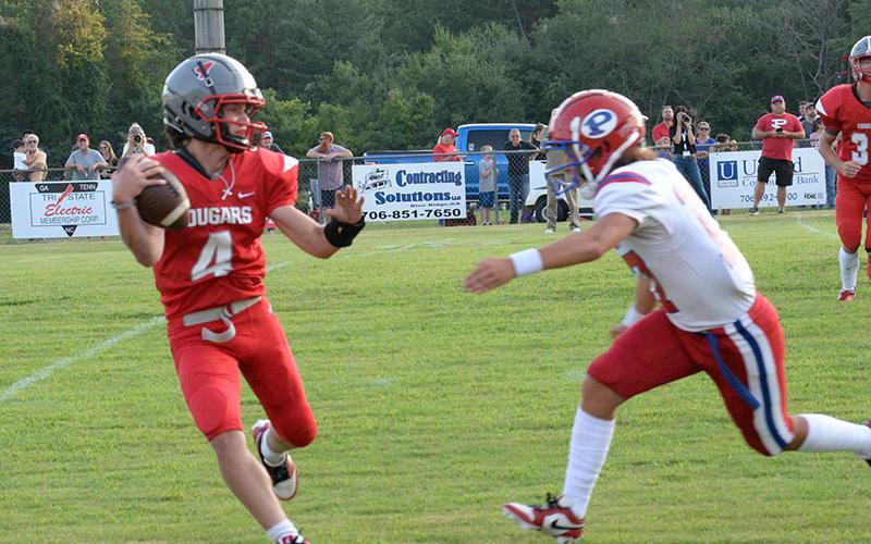 Copper Basin’s Cade Dean (4) is chased by a Polk County defender in the Cougars season opener Friday night.