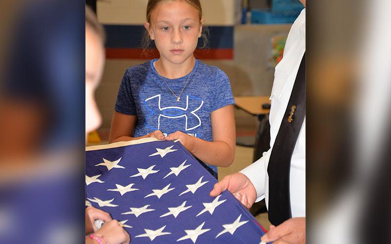 Alexandria Evans pays close attention as she learns how to properly fold a United States flag. Each year members of Fannin County veterans groups visit fifth grade classes to present a program on flag etiquette.