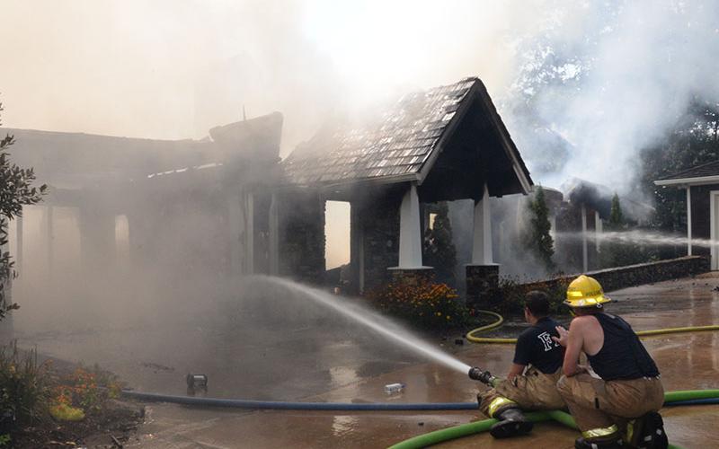 Firefighters battled extreme heat Wednesday, July 26, when they fought a fire at a Blue Ridge Lake home. Despite how close the home was to a garage, at right, and another residence, only the garage suffered very minor damage with a melted gutter