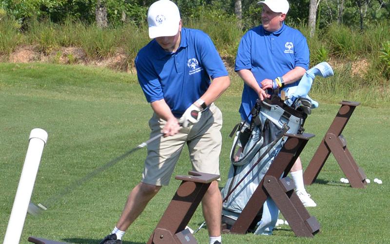 Alex Hughes and Eric Morris are determined to hit their golf balls farther than any other competitor in the Special Olympics Golf Skills Event at Old Toccoa Farm.