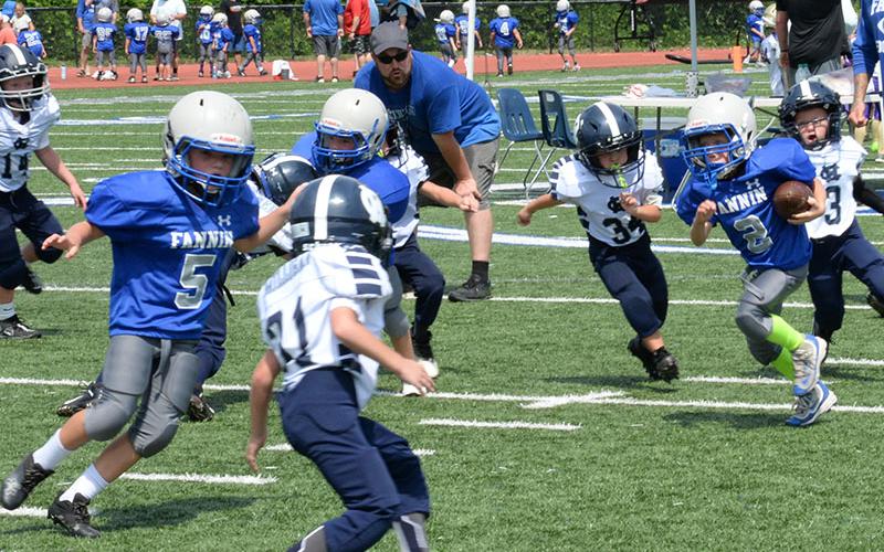 Fannin’s Miller Gryzenia (#2) finds a hole through the line while Robby Evans (#5) looks to make a block to clear the path down field in the Fannin County Rec football game last Saturday.