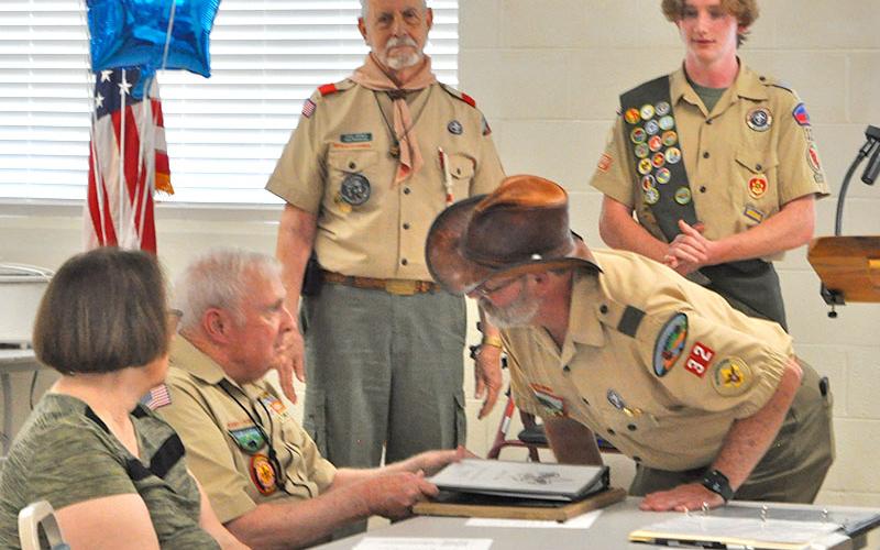Larry Dyer and Troop 32 Scoutmaster David Lewis converse over the awards presented to Dyer at the celebration. Mathew Monroe, Senior Patrol Leader of Troop 32, presented the awards to Mr. Dyer.