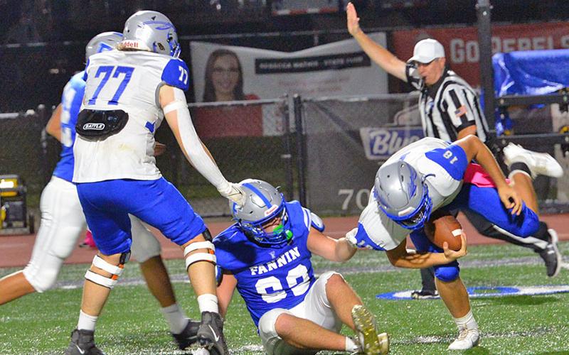 Case Holloway holds on for a quarterback sack against the Gordon Central Warriors Friday night in Blue Ridge. The Rebels scored a 42-0 advantage for their first region win of the season.