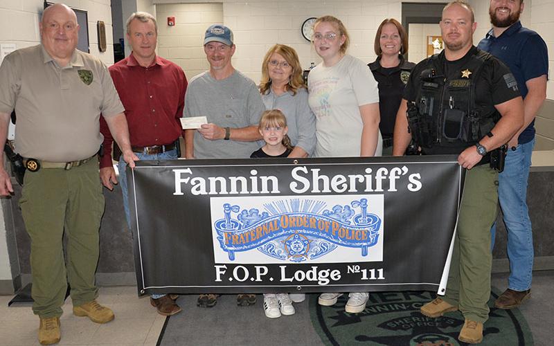Skylar and Riley Gazaway received proceeds from the Corporal Richard Gazaway Memorial Golf Tournament last week. Shown during the presentation of the check at the Fannin County Sheriff’s Office are, from left, Investigations Sergeant J.K. Davenport, Sheriff Dane Kirby, Wayne Stover accepting the donation for the children, Riley Gazaway, Glenda Stover, Skylar Gazaway, Investigator Erin Sehl, Sergeant Jacob Pless and Investigator Dustin Carder.