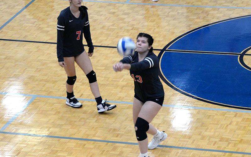 Nicole Marie (#13) sets up a return for the Lady Cougars as Sarah Collis (#7) waits.