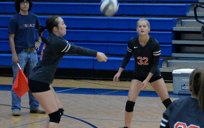 Maddie Cribbs sets up a return for the Lady Cougars as Riley Hall (32) waits fo the shot.