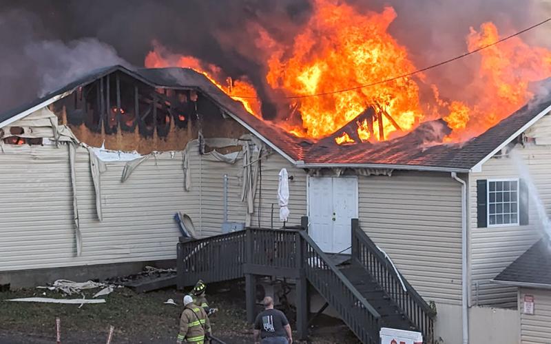 A huge cloud of black smoke rises into the air from the flames consuming Fieldstone Village.