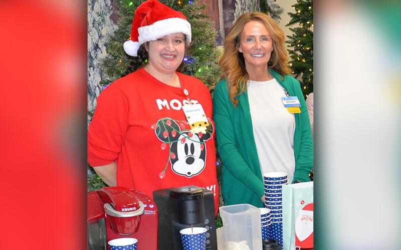 Walmart employee Amber Chadwick, left, and store Manager Sherry Neal served hot chocolate and snacks to Shop With A Cop participants.
