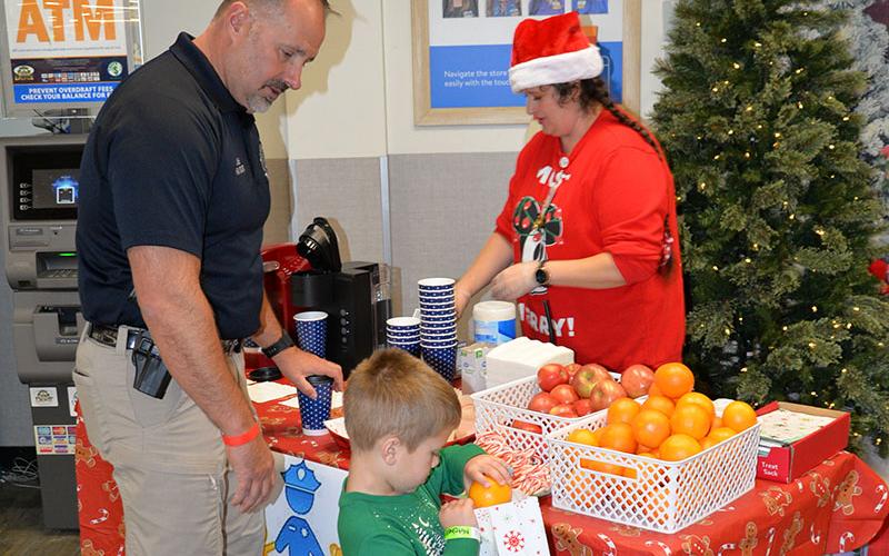 Blue Ridge Police Chief Robbie Stuart helped Mitchell Walker gather a few treats provided by the Blue Ridge Walmart for Shop With A  Cop.