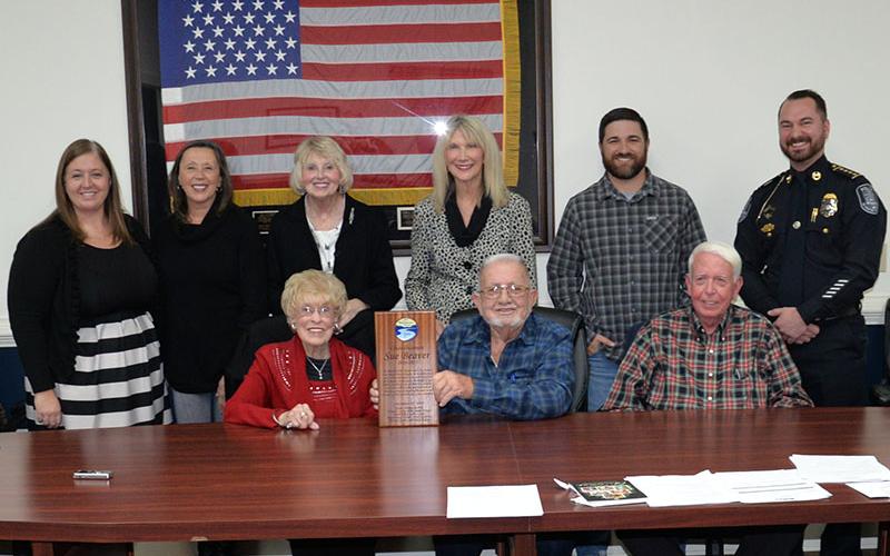 Sue Beaver was honored for her years of dedication by fellow McCaysville city officials at the December meeting of the city council. Shown following the presentation are, from left, front Beaver, Mayor Thomas Seabolt, and Councilman Larry Collis; and, back, City Attorney Cortney Stuart, City Clerk Nancy Godfrey, Coucilwomen Gilita Carter and Susan Kiker, Councilman Jason Woody and Police Chief Michael Earley.