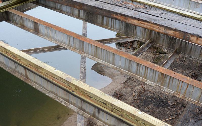 The deck of the steel bridge is being removed all the way to the supporting steel.