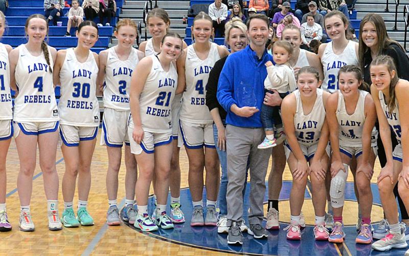 Fannin County Lady Rebels Head Coach Ryan Chastain was honored by the Fannin County Sports Hall of Fame for his 100th win in a brief ceremony Saturday. Shown helping Chastain celebrate are, from left, Jace Sanderson, Emma Buchanan, Avi Ethington, Albany Cole, Annabelle Anderson, Maggie Ledford, Emma Holloway, Amanda Chastain, Ryan Chastain, Ella Kate Chastain, Callie Ensley, Reese Lewis, and Addison Smith; and front, Izzie Jabaley, Courtney Davis, and Macy Hawkins.