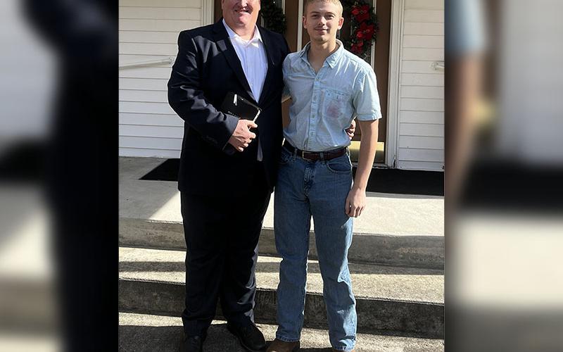 Tristen Siler stands outside the entrance to Macedonia Baptist Church with Pastor Joey Patterson.