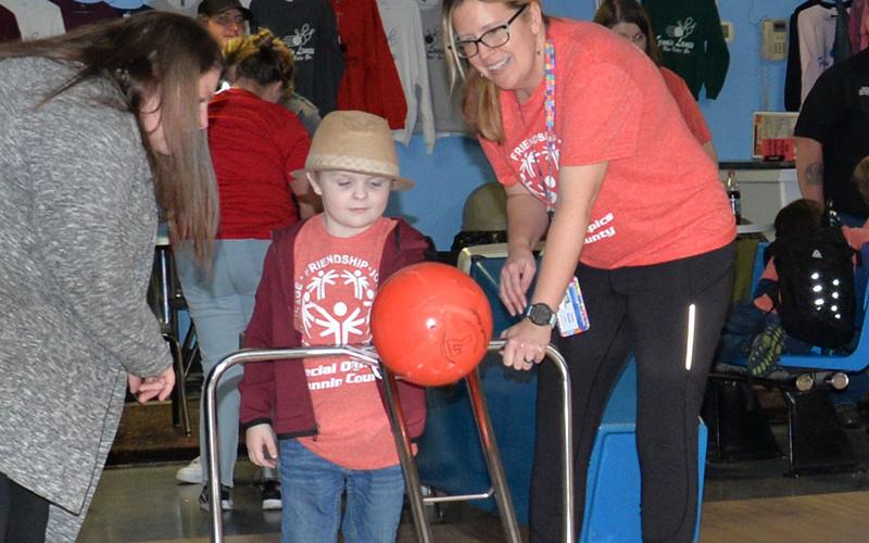 Maxwell Brown gets help from Mrs. Burner as they carefully work together to line up his next attempt during Special Olympics bowling.