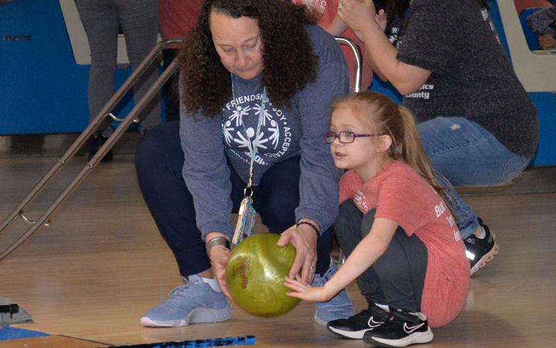 Kinsley Marlow of East Fannin Elementary gets a hand from Mrs. Jones as she lines up her next roll.