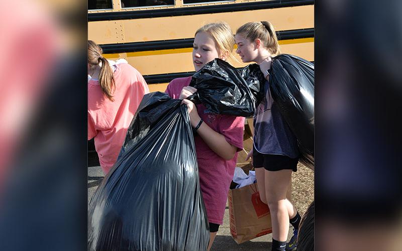 Karleigh-Jayne Stiles and Lillie Williams load bags almost as big as they are as part of students efforts to help the homeless.