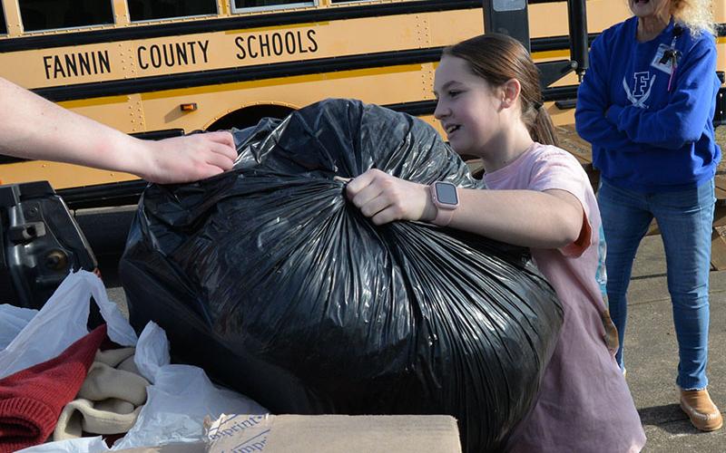 Fannin County Middle School (FCMS) student Lennox Patterson loads a bag filled with items to help Fannin County’s homeless population into the back of a pickup truck. FCMS students collected over 4,000 items in a school wide competition.