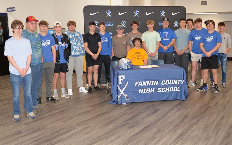 Several members of the Fannin County Rebel football team showed up to support Brody Paskill, seated, when he signed his Letter of Intent to play football at Point University. Players there to congratulate Paskill were, from left, Castle Barnett, Isaiah Stephens, Nate O’Neal, Baylor Twiggs, Scott Waldrep, Braxton Cheatham, Barron Davenport, Brayden Taylor, Judah Wood, Case Holloway, John Holsonback, Luke Holsonback, Andrew Nuckolls, Noah Burnette, CJ Reece and Matthew Ponton. Paskill also received an academi