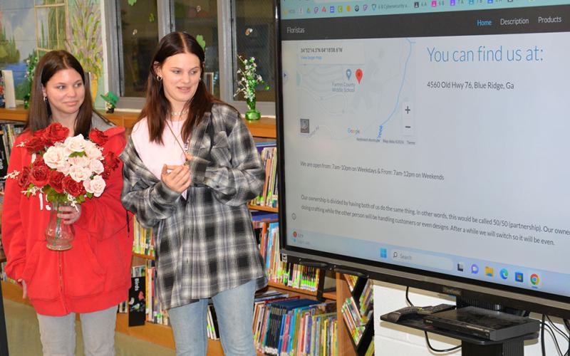 Fannin County Middle School students Tamara Tolli, left, and Kinslee Gravley present their floral business, Florista’s, at the middle school Shark Tank competiton last week.