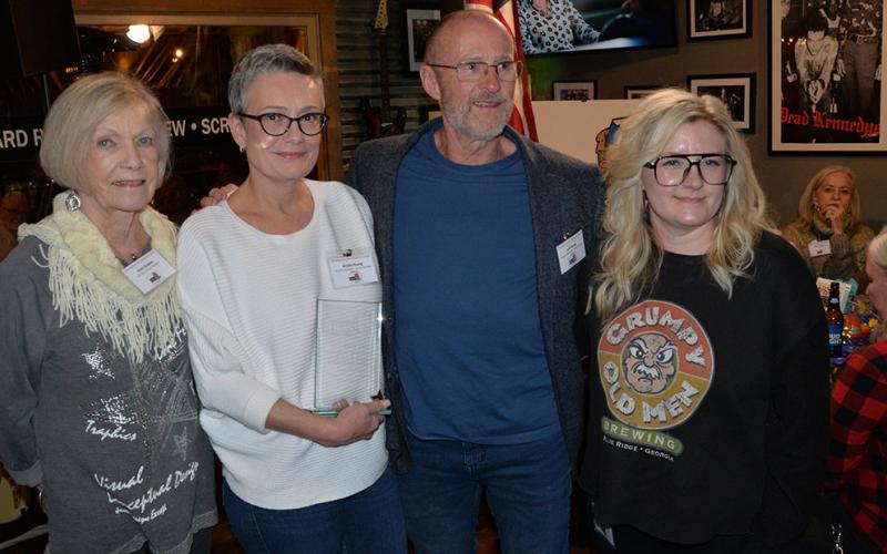 Kristie and Jeff Young, from left, and Taproom Manager Bethany Meyer received the Business Champion Award presented by Snack in a Backpack.