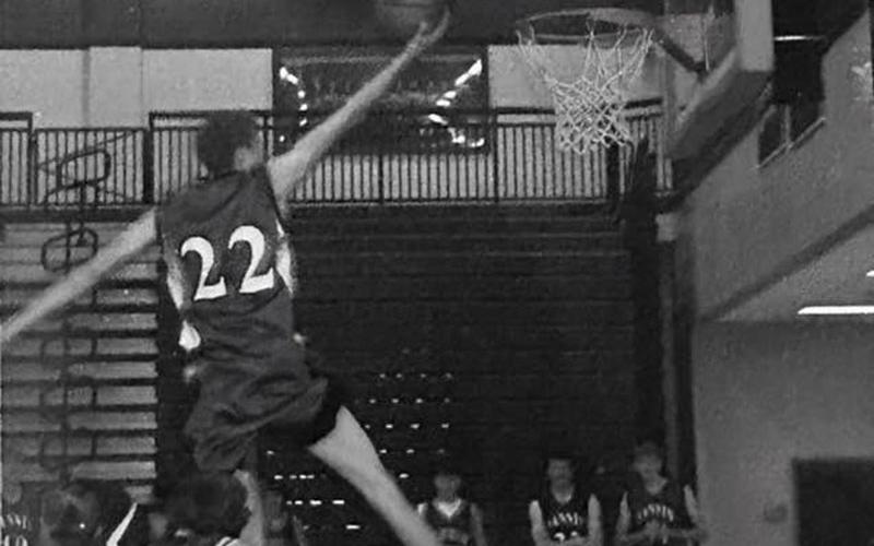 Seth McClure, jersey number 22, soars above the rim.
