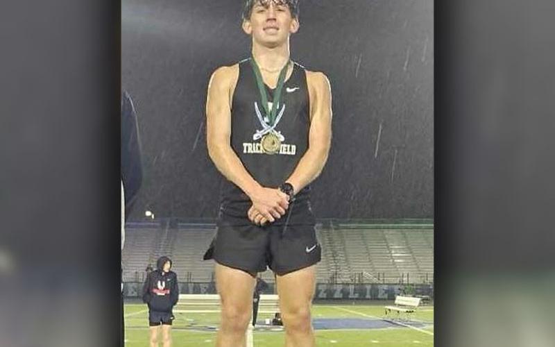 Zechariah Prater is shown on the podium after finishing first in the 1600 meter run.