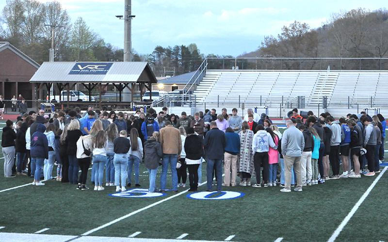 A large group gathers around Hunter Satterfield as he begins the candlelight vigil to offer prayers and thoughts for the Holsonback family with an opening prayer. The vigil was held on the Fannin County High School football field last week to remember the death of John Holsonback, the injuries to his siblings, and to lift up the entire family.