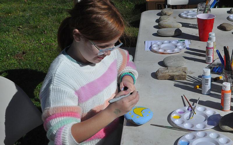 Ruby Shults was excited to tour Project Chimps Saturday. While waiting she painted a banana on a rock at the tables set up for rock decorating.