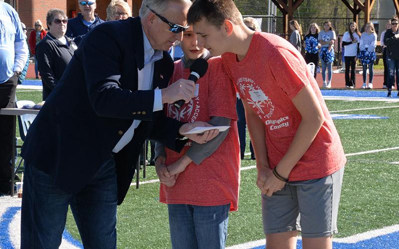 Georgia Seventh District House Representative Johnny Chastain helps Eli and Maddix from Fannin County Middle School say the Olympic oath.
