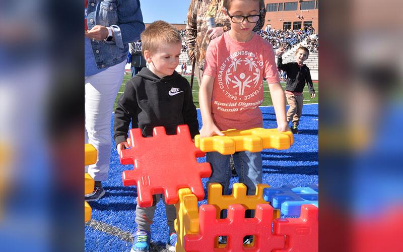 Carter, right, from East Fannin Kindergarten gets help with his construction project.