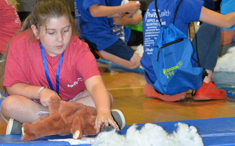 Chloe Wishhart concentrates on creating her own stuffed animal at the May 18 camp.