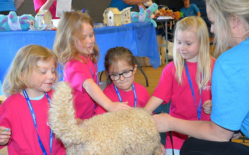 Laci Swafford, Lyla Swafford, Lillian Ritter, and Carolina Wishhart, from left, enjoyed the visit from Lauren Adams’ and her dog, Bonnie, at Camp Cocoon. The visit was part of the planned activities at Camp Cocoon, but it was certainly a way to put smiles on faces who were heard to say, “I love dogs.” Children were later treated to a petting zoo brought in for the day.