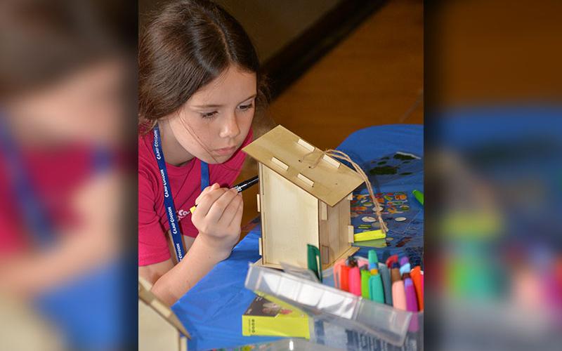 Quincy Adams concentrates to put the final prepartions on her birdhouse at Camp Cocoon.