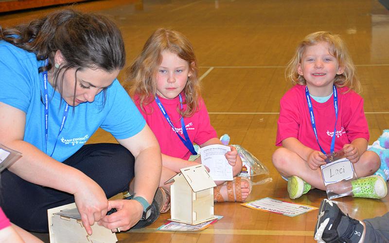 Morgan Thomas, left, gives Lyla Swafford a hand in putting the final touches on her birdhouse.