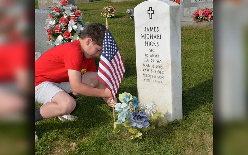 Kyle Allen places a flag at J.P. Chastain Memorial Park in Blue Ridge as veterans are honored for Memorial Day.