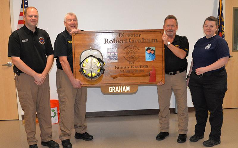 Forty four years of service requires a big plaque, or at least it did for Robert Graham. Graham, second from left, receives the huge wooden commemorative from, from left, new Emergency Management Agency Director Patrick Cooke, Fire Chief Larry Thomas and EMS Supervisor Becky Huffman. The presentation was made during a reception in Graham’s honor at Fire Station #1 in Blue Ridge Thursday, May 16.
