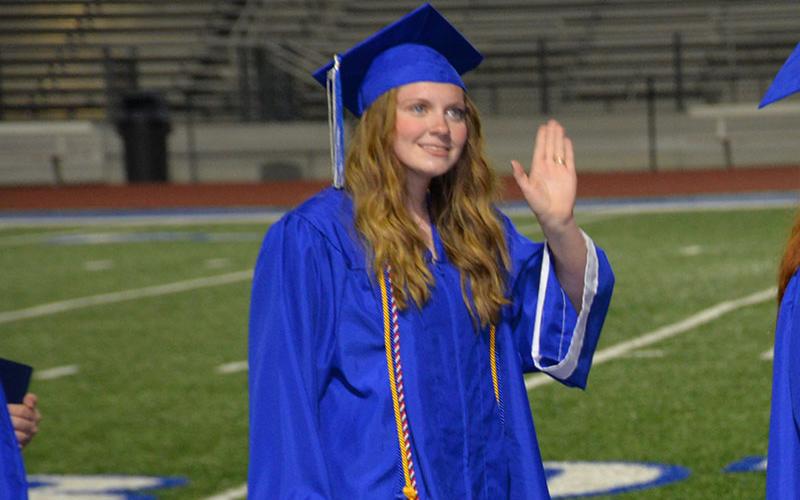 Graduate waves to family and friends.
