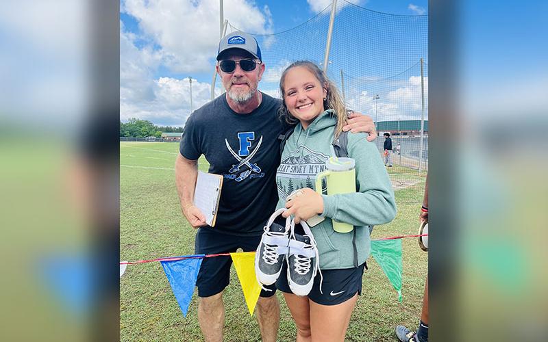 RICHT: Sydney German is shown with Throwing Coach Jeff Kuma at the Track &amp; Field Sectionals Meet. German placed eighth in the Shot Put, earning her the right to compete in the State Championships.