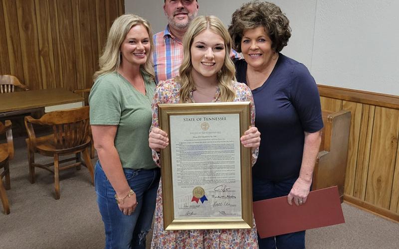 Zoie Hatcher holds the framed copy of the Tennessee House of Representatives resolution in her honor presented by State Representative Dan Howell. With her are, from left, her parents, Tina and Robby Hatcher, and her “nana”, Regina Raines.