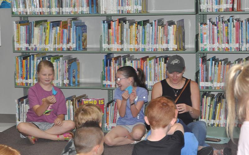 Friends, Olivia Edwards, left, and Zoë Ethington show each other their origami fireflies they made at Fantastic Fireflies during the Summer Reading Program at the Fannin County Public Library last week.