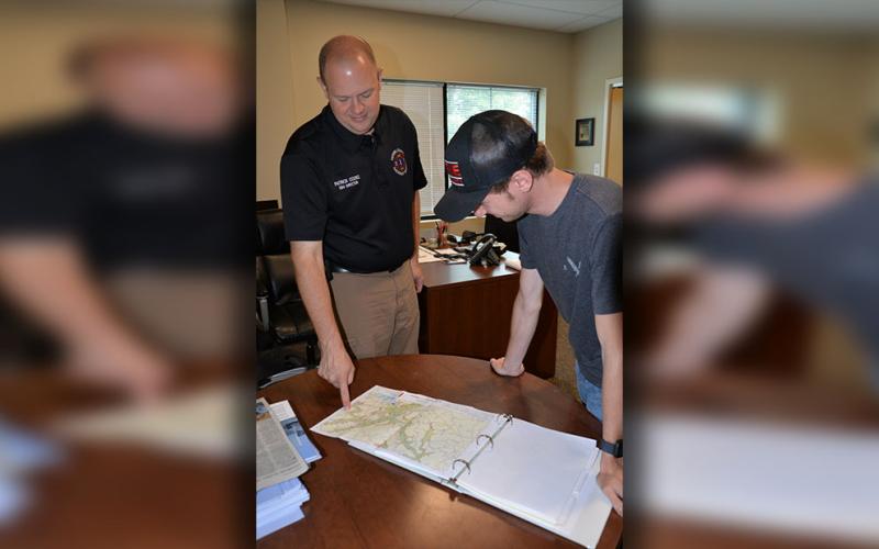 Fannin County EMA Director Patrick Cooke, left, and firefighter Trent Lowery look over TVA maps depicting the results of a catastrophic failure of Blue Ridge Dam. TVA maintains the dam is safe as it prepares for its Thursday, June 27, siren test.
